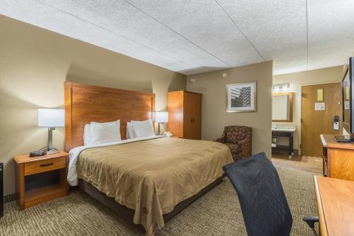 a hotel room with a bed and a desk at GreenRidge Hotel in Wickliffe