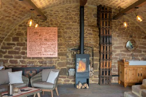 a living room with a fireplace in a stone wall at Burggarten Appartements Neuleiningen in Neuleiningen