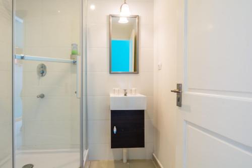 a bathroom with a sink and a shower at Bed & Bike Curacao in Willemstad