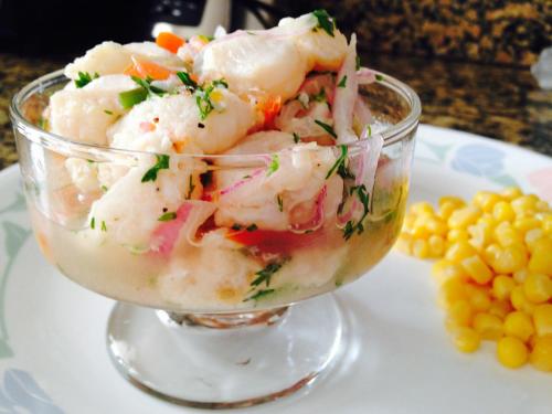 un plato de vidrio de camarones en un plato con maíz en Pico Alto Surf, en Punta Hermosa