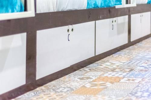 a bathroom with a tile floor and white cabinets at Bed & Bike Curacao in Willemstad
