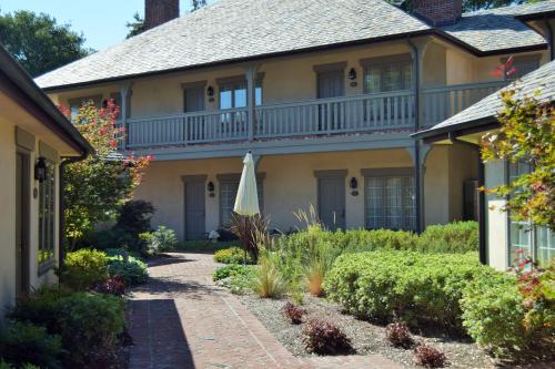 a large yellow house with an umbrella in the yard at Vineyard Country Inn in St. Helena