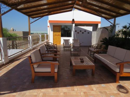 a patio with chairs and a couch and a table at Hotel Las Flores in Ica