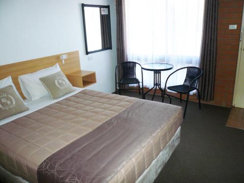 Habitación de hotel con cama, mesa y sillas en Grong Grong Motor Inn, en Grong Grong