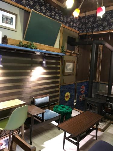 a room with tables and chairs and a chalkboard on the wall at Shabby House in Sapporo