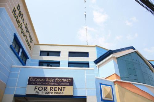 a building with a for rent sign in front of it at Dumaguete Springs Apartment in Dumaguete