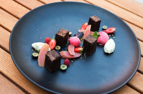 a blue plate with chocolate and strawberries on a table at Maison Bistro & Hotel in Budapest