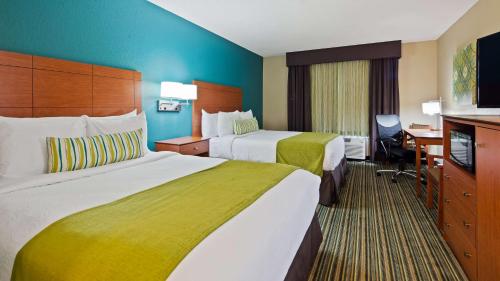 a hotel room with two beds and a desk at BEST WESTERN Plus Menomonie Inn & Suites in Menomonie