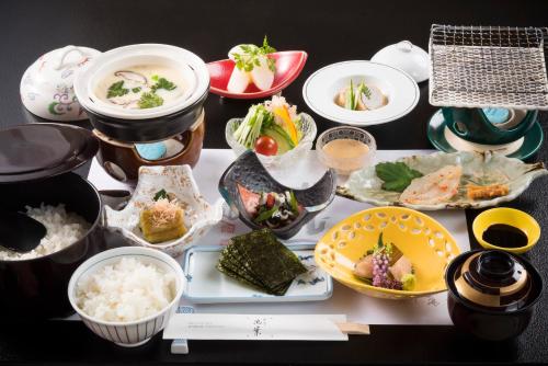 einen Tisch mit Schalen und Teller mit Lebensmitteln in der Unterkunft Ryotei Manyou in Nomi