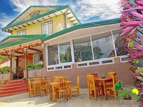 a group of chairs and tables outside of a house at Elmar Cabin in Baguio