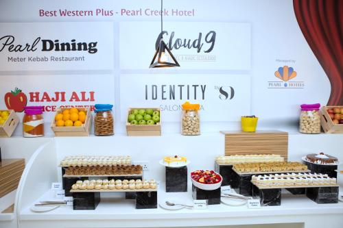 a display of food on a table with fruits and vegetables at Best Western Plus Pearl Creek in Dubai