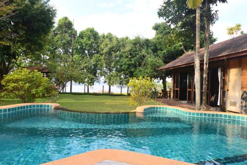 a swimming pool in front of a house at Viang Yonok Hotel, Restaurant, Sports Club in Chiang Saen