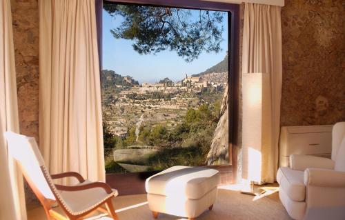 
a room with a chair, table and a window at Mirabó de Valldemossa in Valldemossa
