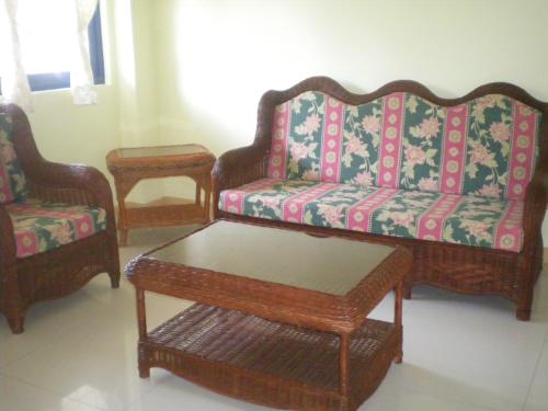 a living room with three couches and a coffee table at Dumaguete Springs Apartment in Dumaguete