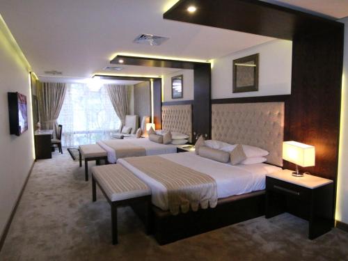 a hotel room with two beds and a couch at Islamabad Hotel in Islamabad