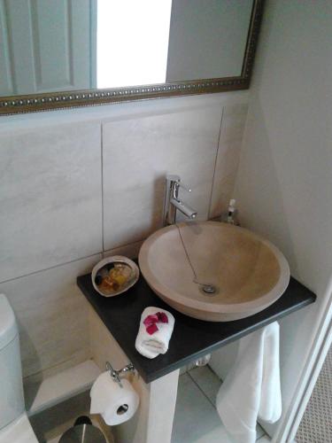 a bathroom with a sink and a mirror at Port House in Bloubergstrand