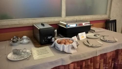 a table with a plate of eggs on top of it at Hotel Corona in Tirano