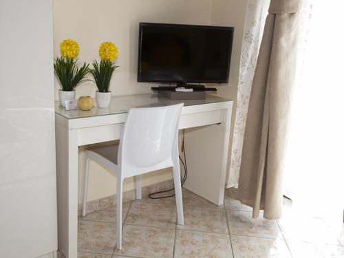 einen weißen Schreibtisch mit einem TV und einem weißen Stuhl in der Unterkunft B&B Feni in Pompei