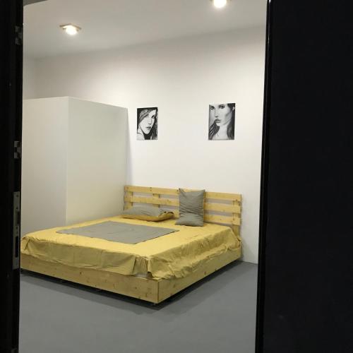 a bed in a white room with pictures on the wall at Central Park Studios in Bucharest