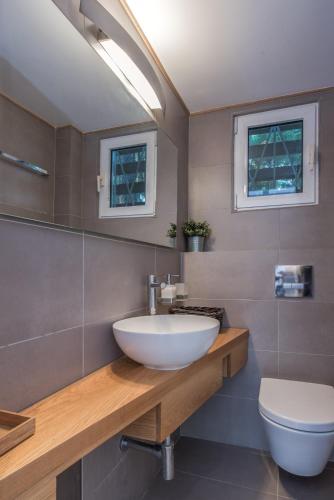 a bathroom with a sink and a toilet at The White Villa at Sani in Sani Beach