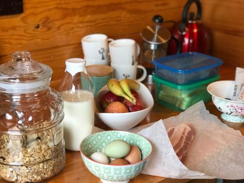 einen Tisch mit Schalen Eiern und einem Glas Milch in der Unterkunft Frankie & Hugh's in Ohakune