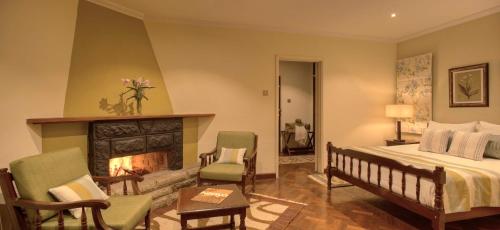 a bedroom with a bed and a fireplace at The Aberdare Country Club in Mweiga