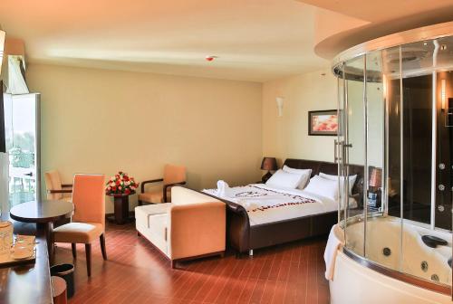 a hotel room with a bed and a bath tub at Magnolia Hotel & Conference Center in Addis Ababa