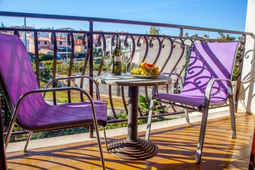 uma mesa e 2 cadeiras numa varanda com uma taça de fruta em Apartments Luce em Rovinj