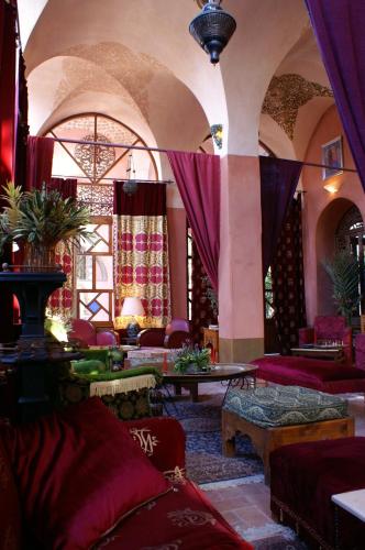 a living room with red furniture and purple curtains at Al Moudira Hotel in Luxor