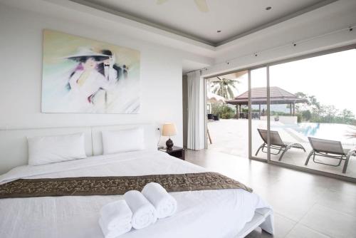 a white bedroom with a large bed and a patio at 5 Bedroom Sea View Villa Bang Por SDV205-By Samui Dream Villas in Ban Bang Po