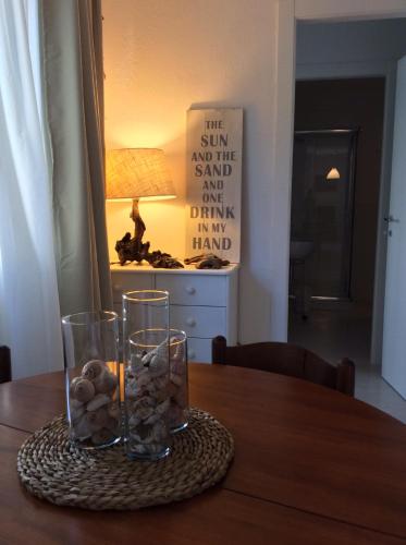 a table with two glasses and a lamp on it at Follow the Sun in Cagliari