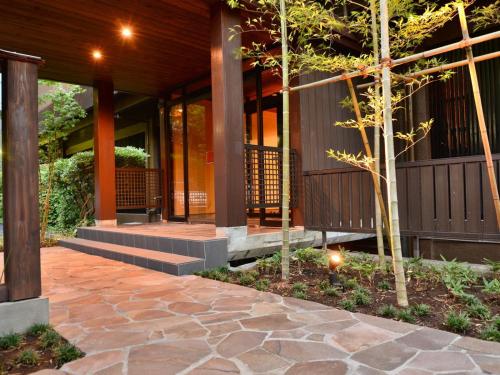 a house with a stone walkway in front of a building at Hatago Kintoen in Hakone