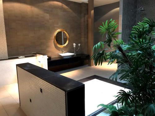 baño con lavabo, espejo y plantas en Fortune Villa Motel en Danshui
