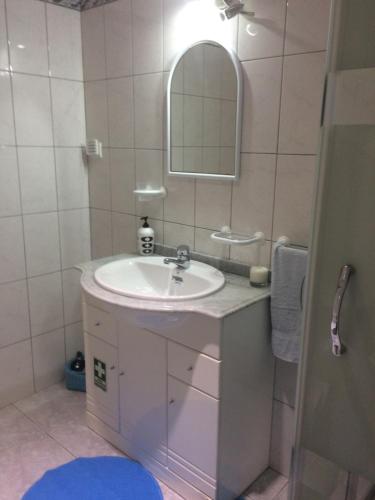 a bathroom with a sink and a mirror at Cantinho Solpraia in Porto Santo