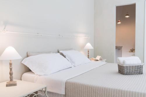 a white bedroom with a bed and a table at BED in BO Saragozza in Bologna