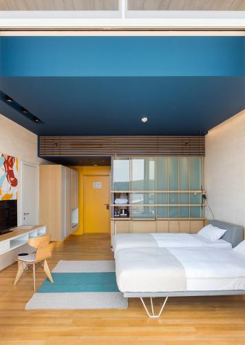 a bedroom with a large bed with a blue ceiling at D-Resort Šibenik in Šibenik