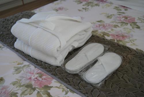 - un plateau avec des serviettes et des chaussons sur un lit dans l'établissement Mas De La Lance, à Roche-Saint-Secret