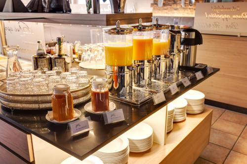 a bar with a bunch of glasses of orange juice at Hotel Die Kleine Blume in Erfweiler