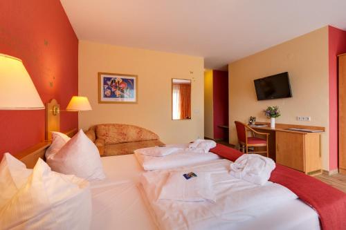 a hotel room with two beds with towels on them at Hotel Die Kleine Blume in Erfweiler