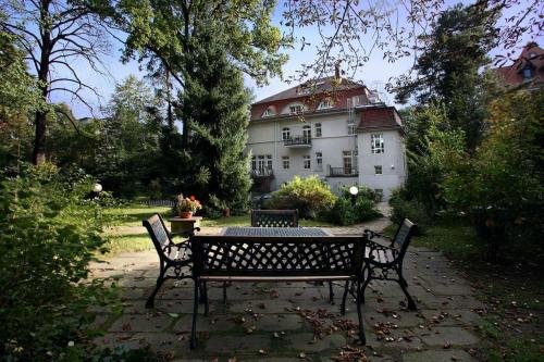 a table and benches in front of a house at Aparthotel Villa Freisleben in Dresden