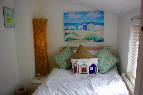 a bedroom with a bed with a house pillow on it at Seaside Fisherman Cottage Southwold in Southwold