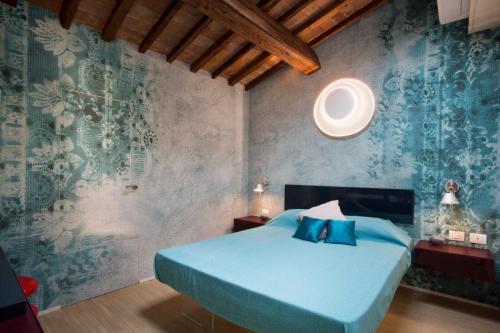 Un dormitorio con una cama azul y una pared en Le Residenze a Firenze - Residenza Covoni Apartment in the historical center of Florence en Florencia