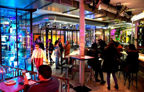 un grupo de personas en un restaurante con gente caminando por ahí en Erlebnis Post - Stadthotel mit EigenART, en Spittal an der Drau