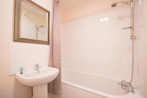 W łazience znajduje się umywalka, toaleta i lustro. w obiekcie Town or Country - Jessie Terrace House B w Southampton