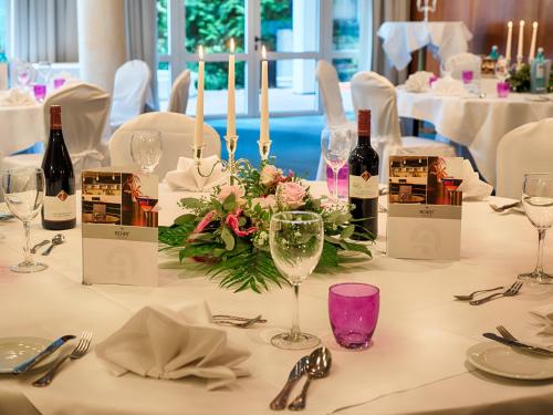 a table with wine bottles and flowers on it at ACHAT Hotel Bad Dürkheim in Bad Dürkheim