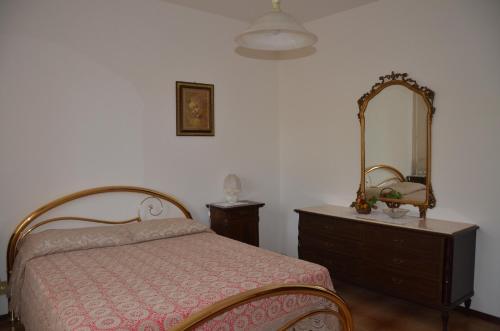 1 dormitorio con cama, tocador y espejo en La Rinascita, en Crespina