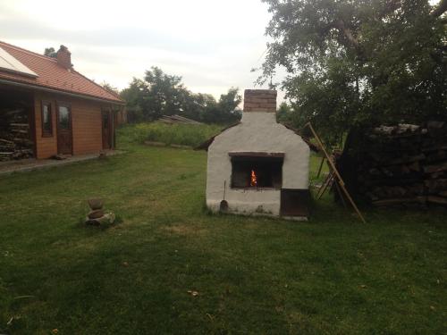 a small fireplace in the yard of a house at Eszter Guesthouse in Sîncrăieni