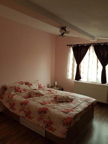 a bedroom with a bed with a floral comforter at Amma in Braşov