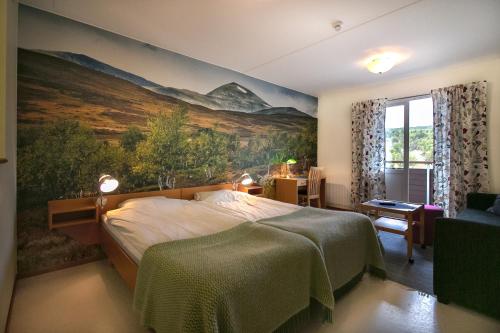 - une chambre avec un lit orné d'une peinture murale dans l'établissement Hotell Bruksvallsliden, à Bruksvallarna