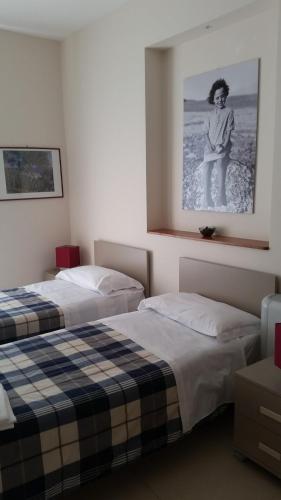 two beds in a room with a picture on the wall at Sorge Palace in Mussomeli